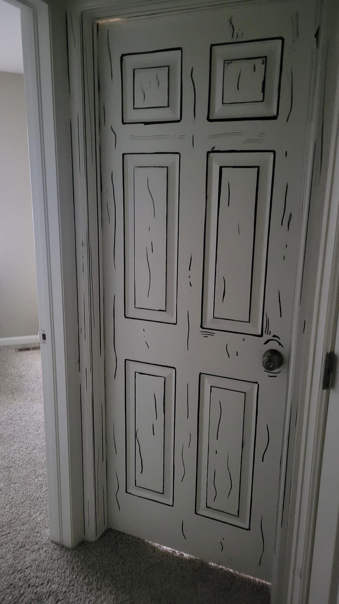 White paneled door covered with loose black outlines and marks